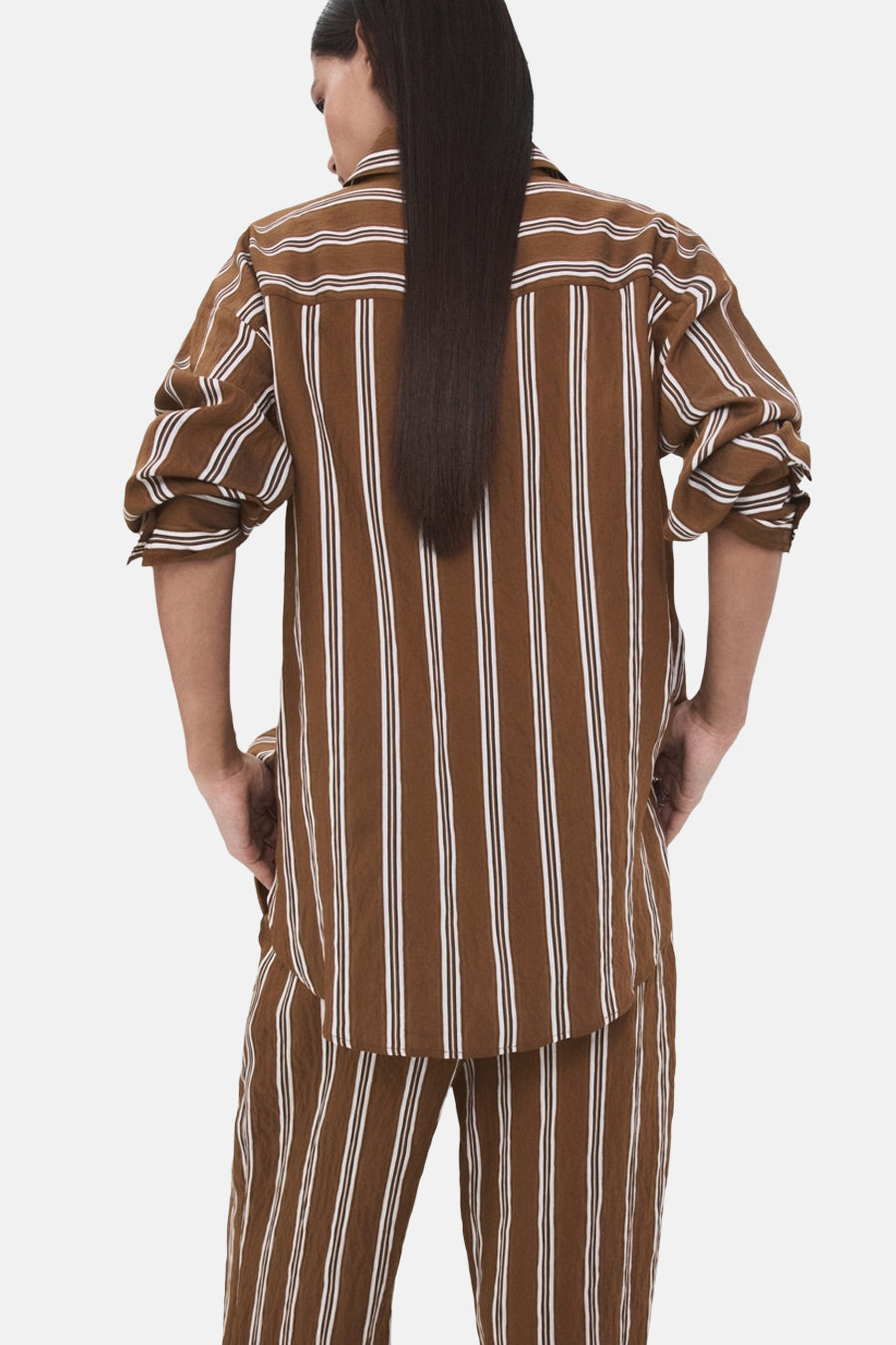 Chemise à manches longues brune rayée de MANGO, avec des rayures verticales blanches et une coupe décontractée.
