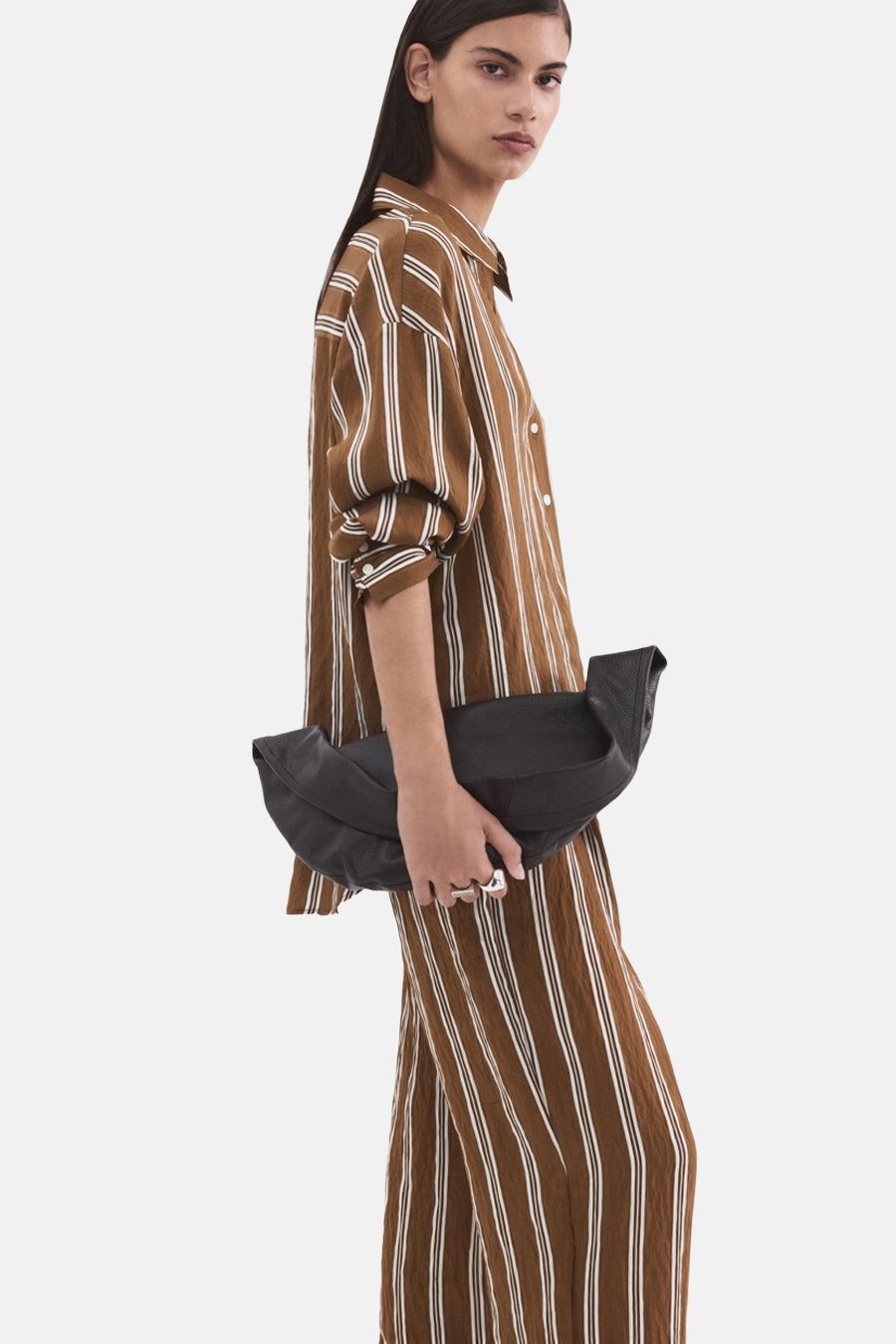 Bruine gestreepte blouse met lange mouwen van MANGO, gedragen met een bijpassende broek en een zwarte handtas.