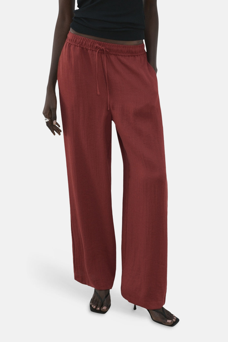Bruine broek van MANGO, wijde pasvorm, getextureerde stof, gedragen met een bijpassend topje, achtergezicht.