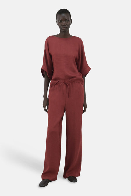 Pantalon brun van MANGO, large et fluide, avec cordon de serrage à la taille, porté avec un haut assorti.
