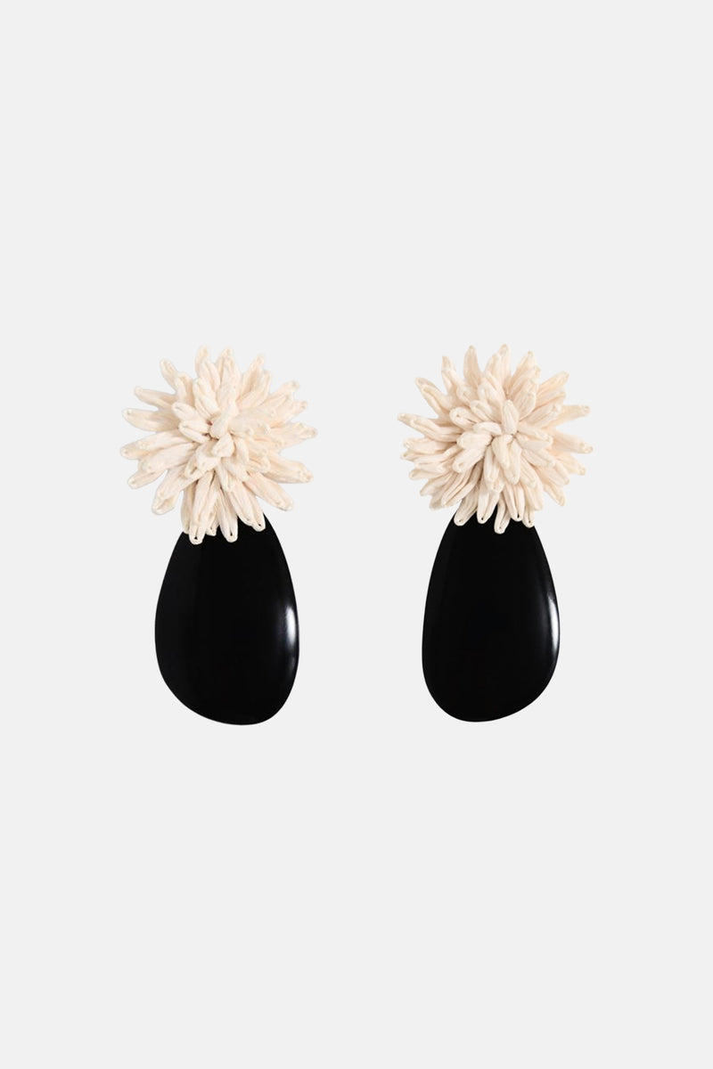 Boucles d'oreilles multicolores de MANGO, avec détail floral blanc crème et forme de goutte noire.