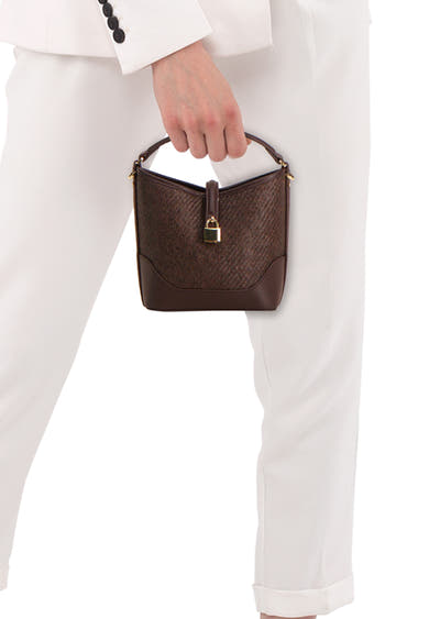 Bruine MANGO handtas met gevlochten body, gladde leren basis en gouden hangslot, in de hand gehouden.
