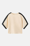 Crèmekleurig blouse met korte mouwen van MANGO, met zwarte bies aan de mouwen en schouders, gedragen met een bijpassende short.