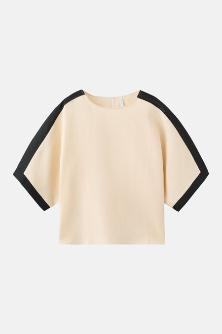 Chemisier à manches courtes beige par MANGO, avec des bandes contrastantes noires sur les épaules et les manches.
