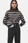 Pull à col rond multicolore de MANGO, à rayures marron et bleu clair, porté avec un pantalon noir et une ceinture noire.
