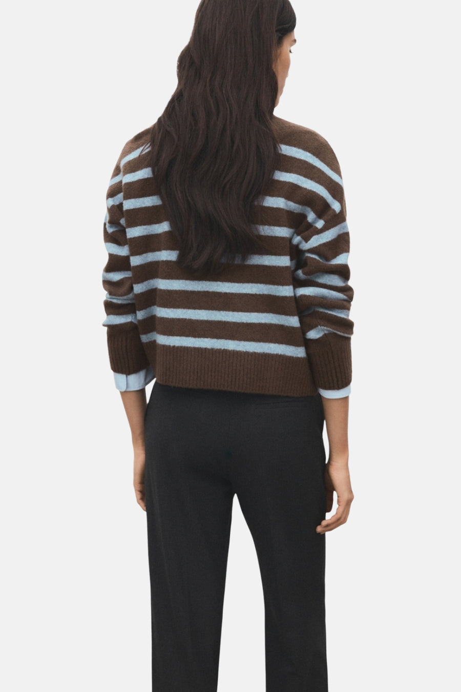 Pull à col rond multicolore de MANGO, à rayures horizontales marron et bleu clair, porté avec un pantalon noir.
