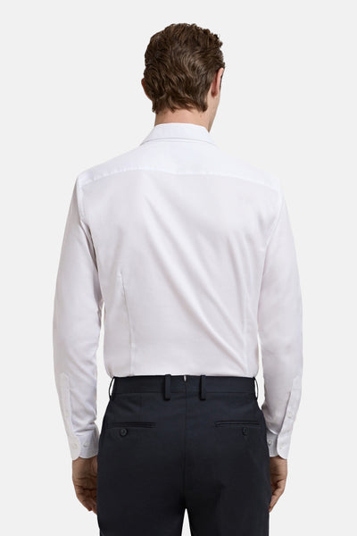 Wit overhemd met lange mouwen van MANGO, van achteren gezien, gedragen met een marineblauwe broek.