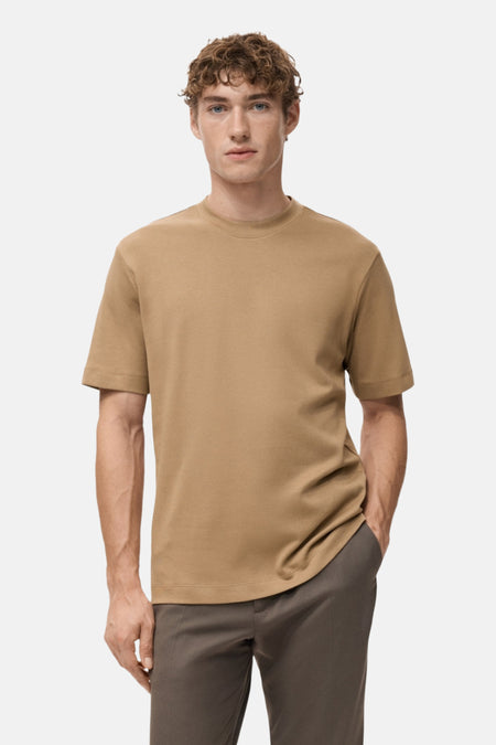 Beige t-shirt met korte mouwen van MANGO, vanachens gezien, gedragen met een neutrale broek.