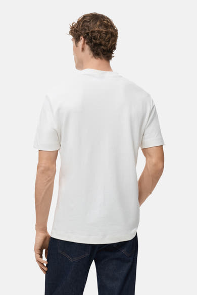 T-shirt à manches courtes blanc de MANGO, vu de dos, porté avec un jean foncé.