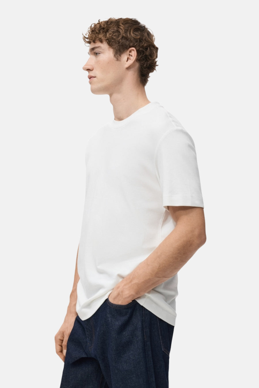Witte t-shirt met korte mouwen van MANGO, gedragen met een donkere blauwe broek, zijkant.