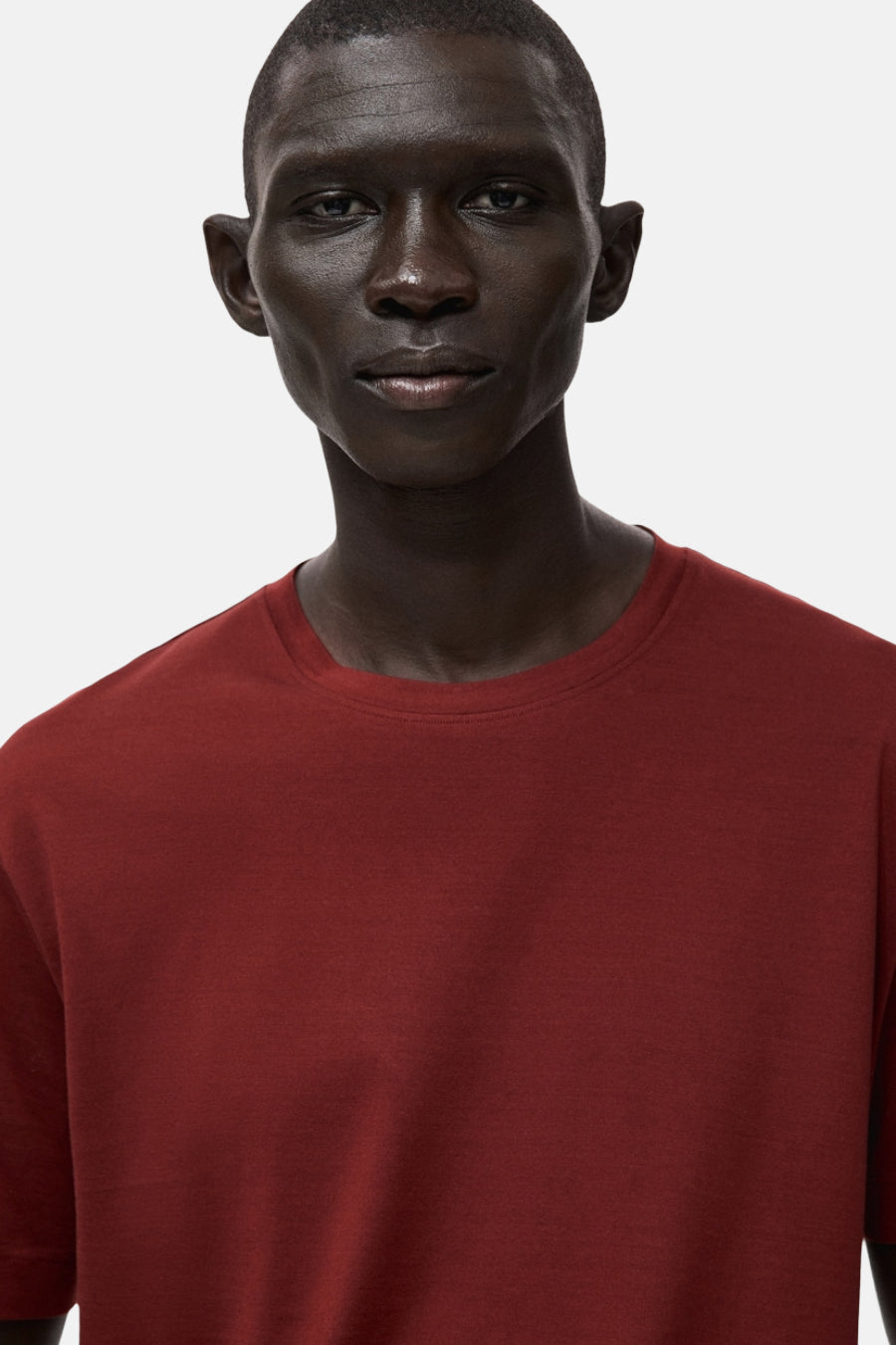 T-shirt rouge à manches courtes de MANGO, uni avec un col rond, porté par un homme.
