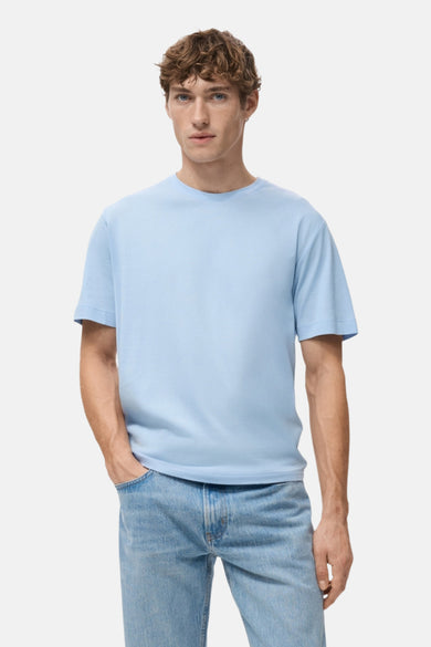 Blauw T-shirt met korte mouwen van MANGO, van achteren gezien, gedragen met een spijkerbroek.