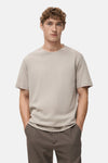 Beige t-shirt met korte mouwen van MANGO, rugweergave, gedragen met eenbrubruine broek.