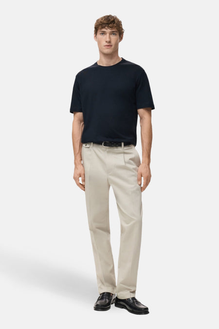 Blauwe t-shirt met korte mouwen van MANGO, gedragen met een beige broek en zwarte mocassins.