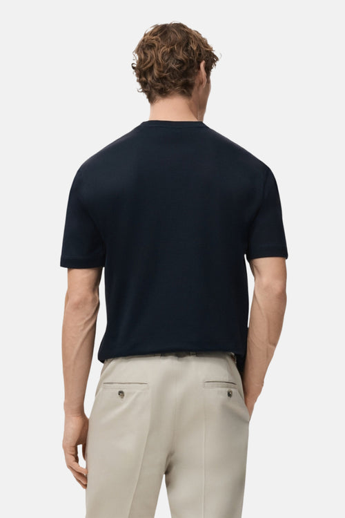 T-shirt à manches courtes bleu de MANGO, porté avec un pantalon beige, vue de dos.