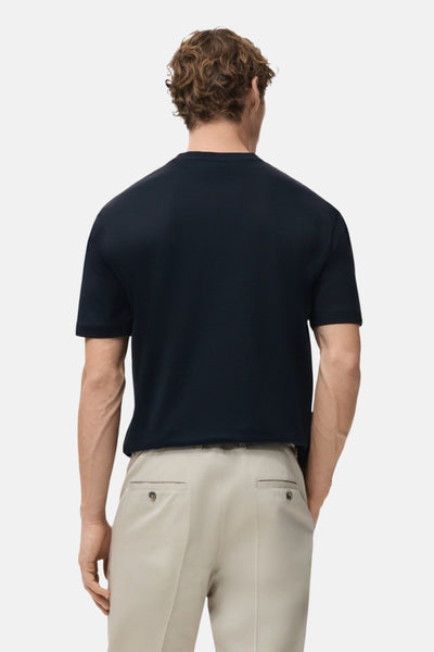 T-shirt à manches courtes bleu de MANGO, porté avec un pantalon beige, vue de dos.