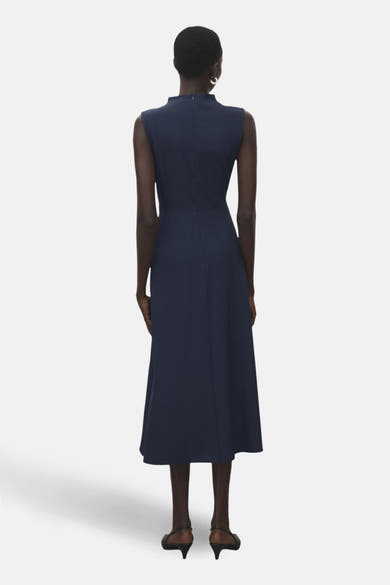 Robe bleue de MANGO, coupe midi trapèze, col montant et sans manches, vue de dos.
