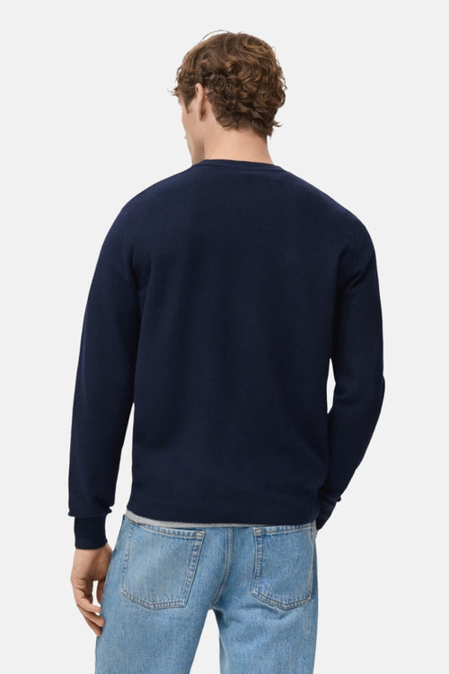 Pull à col rond bleu de MANGO, vue de dos, porté avec un jean décontracté.