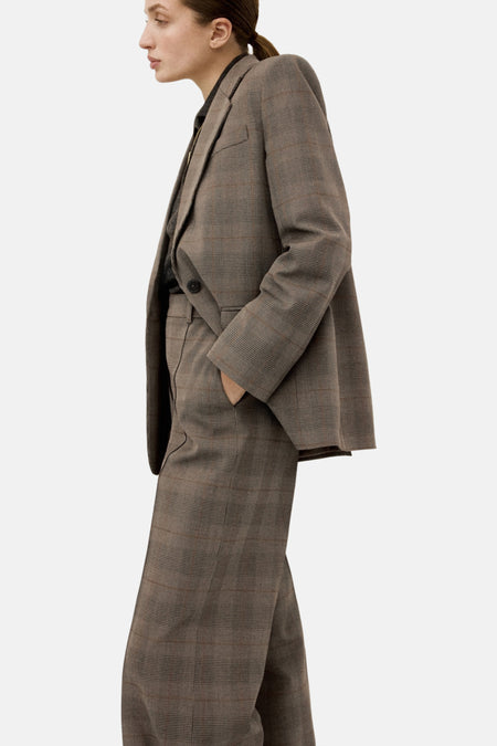 Blazer brun à carreaux de MANGO avec un col à revers cranté et une poche passepoilée.