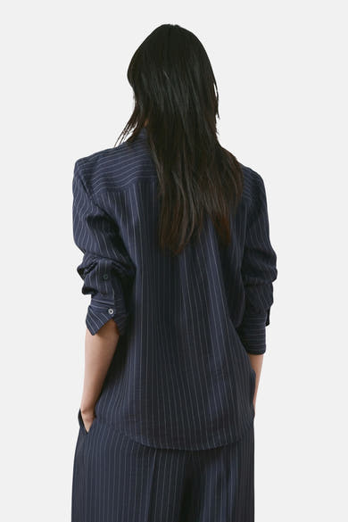 Chemise à manches longues bleue à rayures de MANGO, vue de dos, portée avec un pantalon assorti.