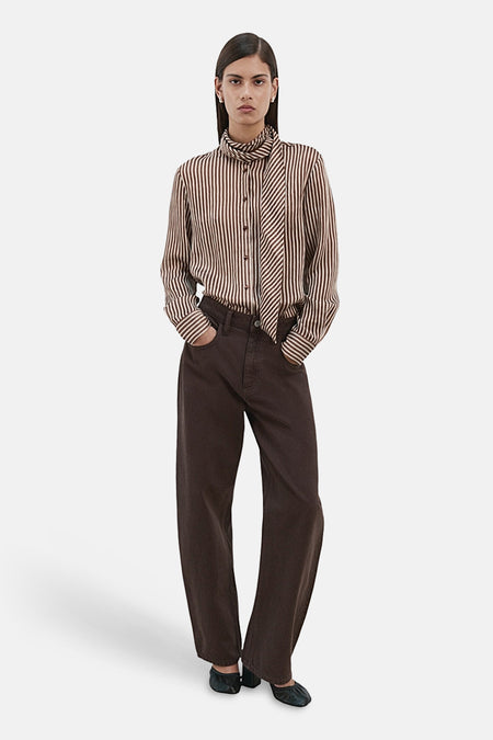 Chemisier à manches longues multicolore de MANGO, à rayures marron et blanches, porté avec un pantalon marron ample.