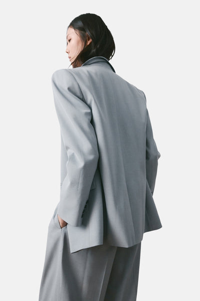 Blazer bleu de MANGO, coupe oversize, porté par une femme vue de dos, avec pantalon assorti.