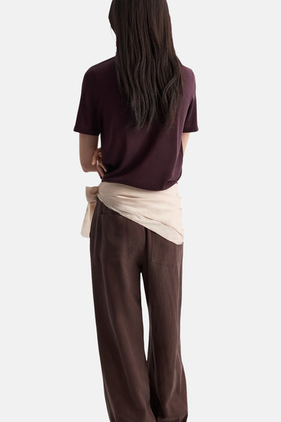 Pull col O bordeaux de MANGO, porté avec un pantalon marron et une ceinture nouée beige.