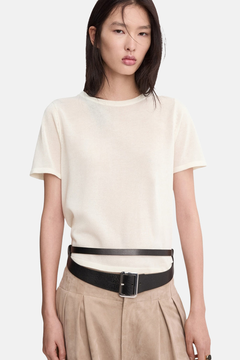 Pull col rond beige de MANGO, porté avec une ceinture en cuir noir, et un pantalon taille haute beige.
