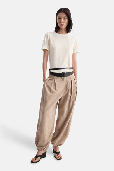 Pull beige col O de MANGO, porté avec un pantalon ample à taille haute et des sandales noires.
