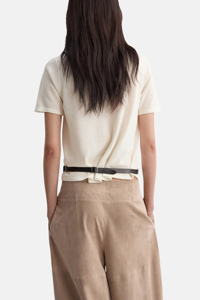 Pull beige col rond de MANGO, porté avec un pantalon taille haute en suède.