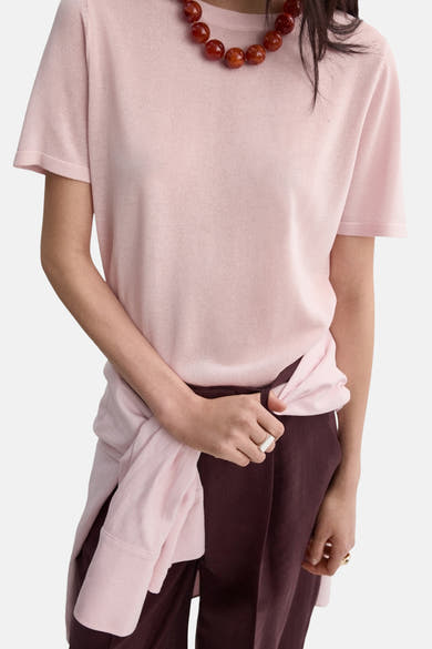 Roze trui van MANGO, gedragen met een bordeauxrode pantalon met hoge taille en rechte pijpen.
