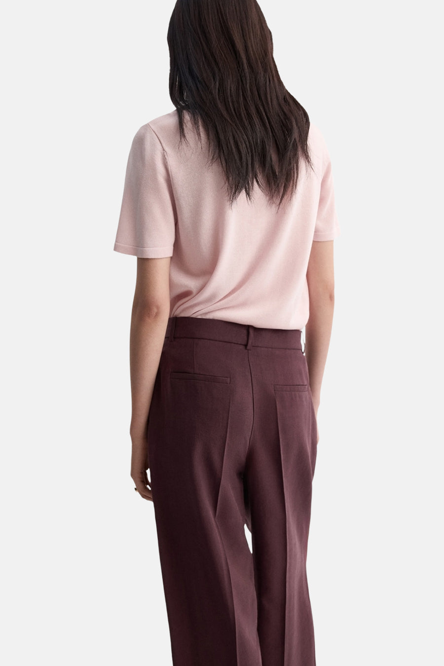 Pull rose de MANGO, porté avec un pantalon bordeaux taille haute et coupe droite.