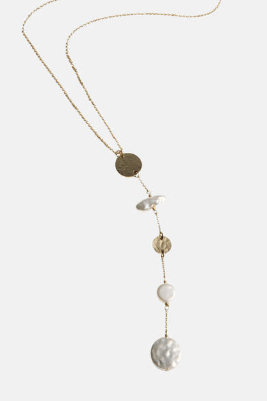 Collier long doré de MANGO, orné de perles et de pièces métalliques, sur un fond blanc uni.
