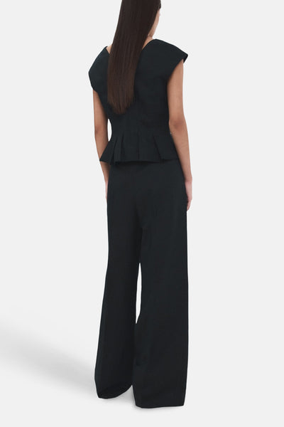 Pantalon bleu de MANGO, coupe ample, avec une texture lisse et des jambes larges, vue de dos.
