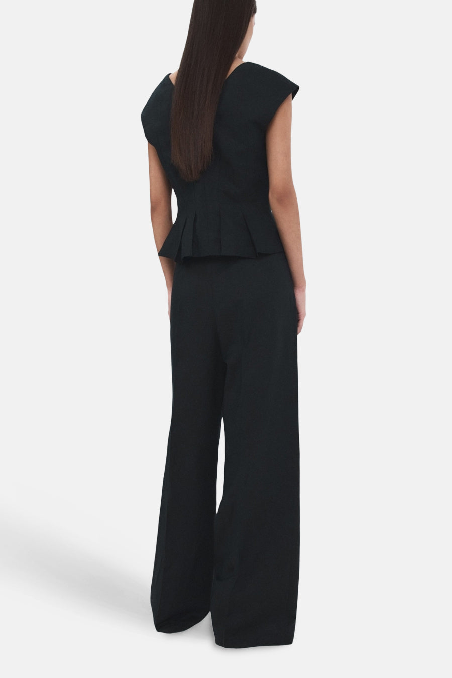 Pantalon bleu de MANGO, coupe ample, avec une texture lisse et des jambes larges, vue de dos.

