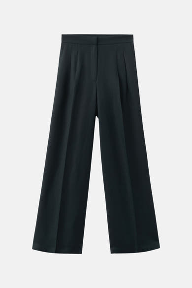 Losse blauwe broek van MANGO, palazzo-model met duidelijke plooien op een effen achtergrond.