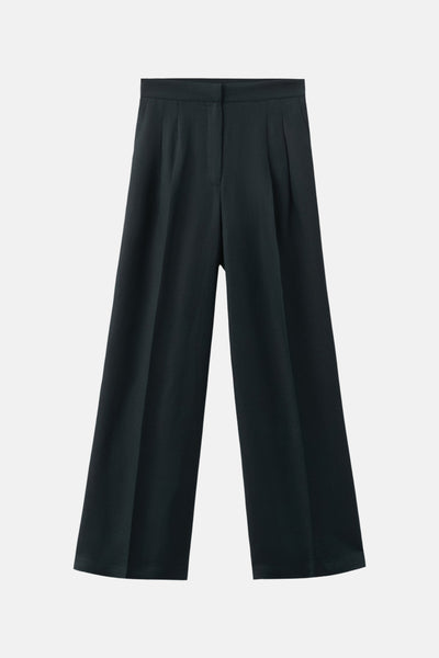 Pantalon bleu ample de MANGO, coupe palazzo avec plis marqués sur fond uni.

