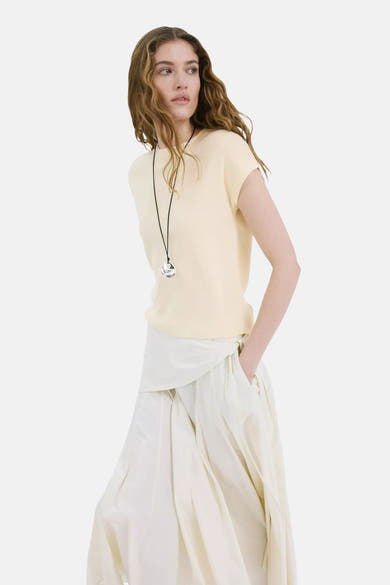 Lichtgeel T-shirt met korte mouwen van fijne tricot van MANGO, gedragen met een wijde ecru broek en een zilveren hanger.