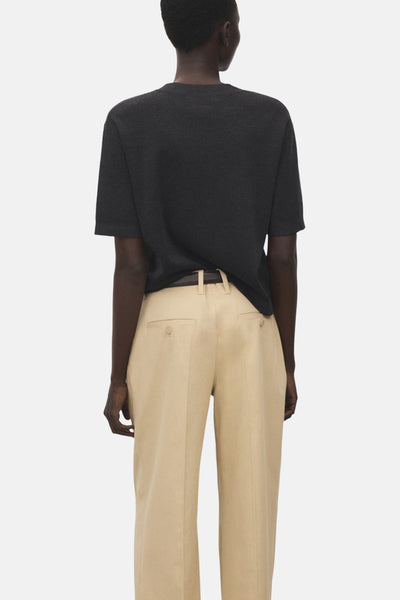 Pull à col rond gris de MANGO, vu de dos, porté avec un pantalon beige.