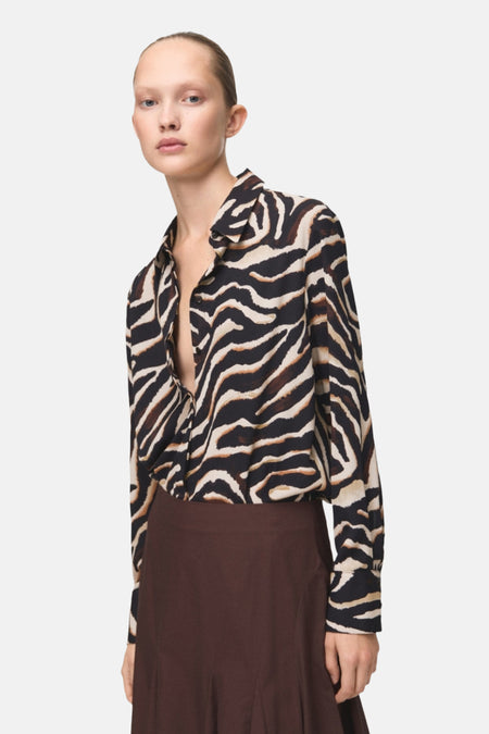 Chemisier à manches longues multicolore de MANGO, imprimé zèbre et porté avec une jupe marron.
