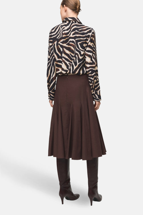 Chemisier à manches longues multicolore de MANGO, à motif zébré, porté avec une jupe marron et des bottes assorties.

