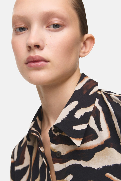 Chemisier à manches longues multicolore de MANGO, avec un motif zébré marron et beige.