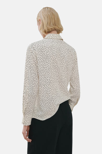 Multikleuren blouse met lange mouwen van MANGO, met zwart stippenpatroon, gedragen met een zwarte broek.