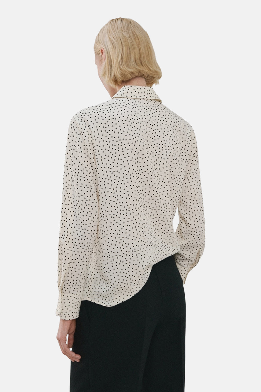 Multikleuren blouse met lange mouwen van MANGO, met zwart stippenpatroon, gedragen met een zwarte broek.