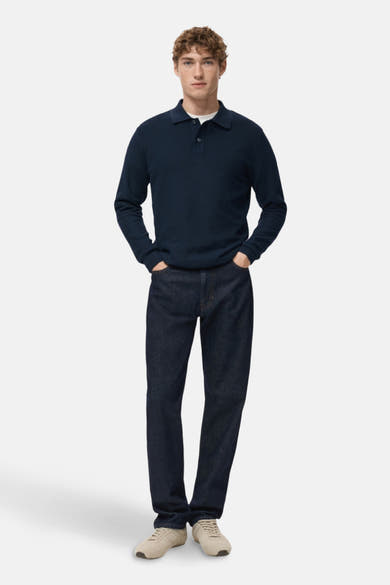 Blauwe V-hals trui van MANGO, gedragen met een donkere jeans en crèmekleurige sneakers.