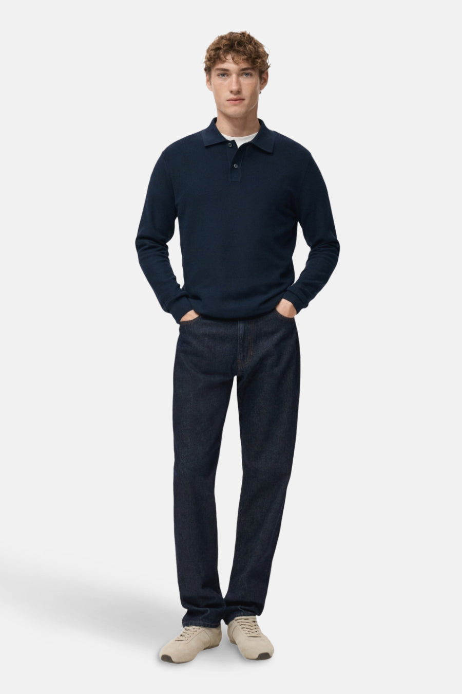 Blauwe V-hals trui van MANGO, gedragen met een donkere jeans en crèmekleurige sneakers.