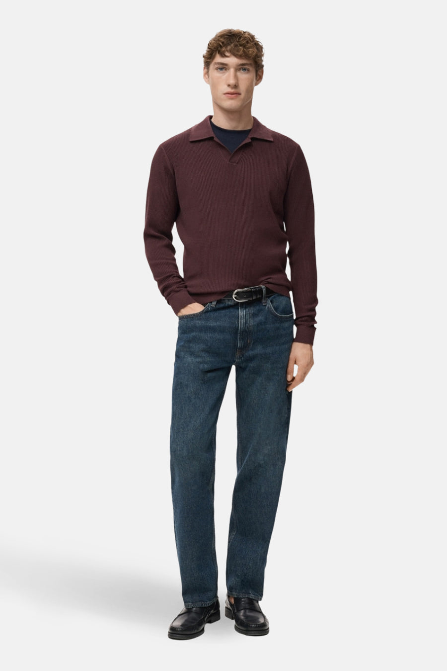 Pull à col en V bordeaux de MANGO, porté avec un jean bleu et des mocassins noirs.