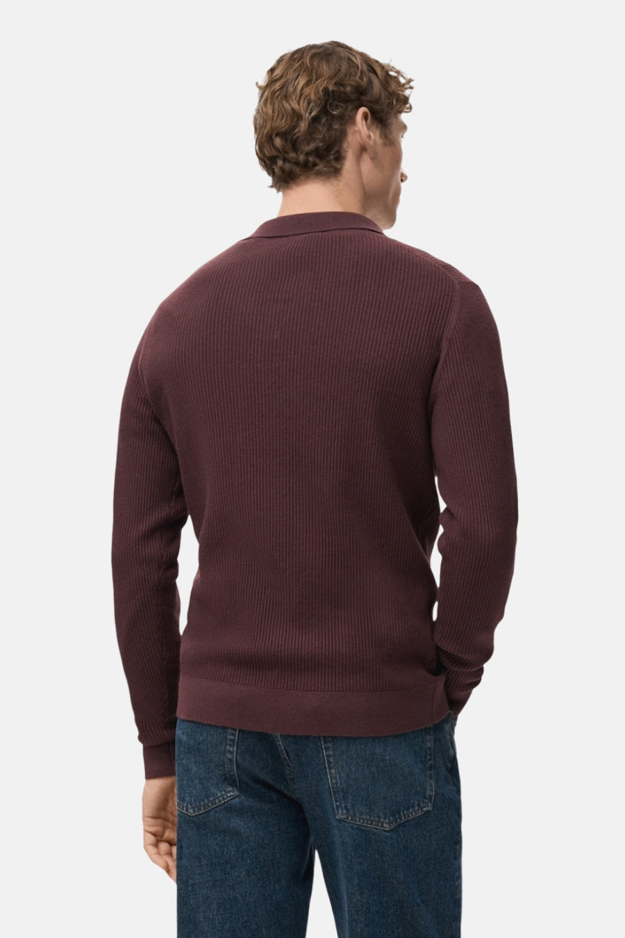 Pull à col en V bordeaux de MANGO, en maille côtelée, porté avec un jean bleu.