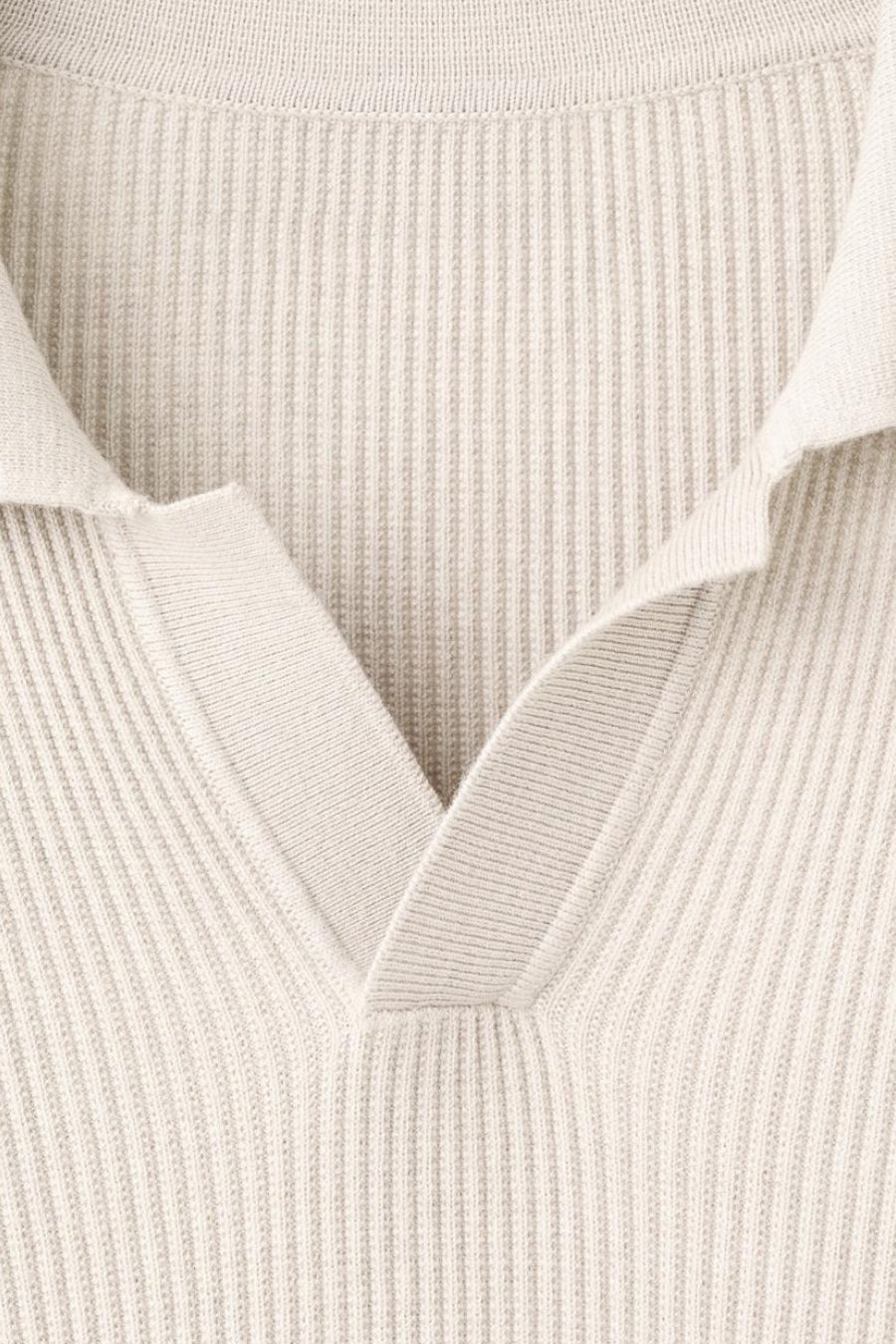 Pull à col en V beige de MANGO, en maille côtelée avec un col ouvert.