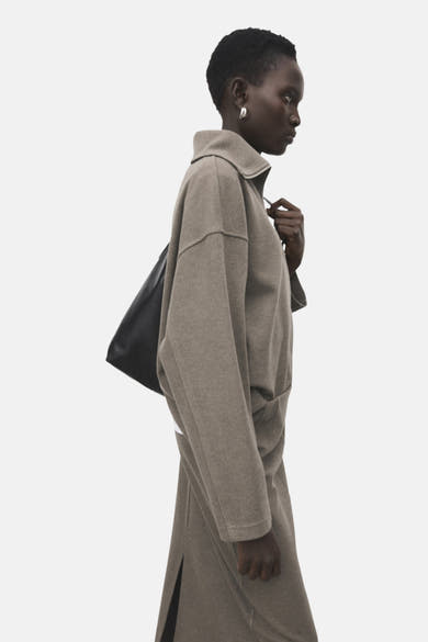 Bruine MANGO-sweatshirt, losse pasvorm, klassieke kraag, gedragen met een wit T-shirt en een bijpassende rok.